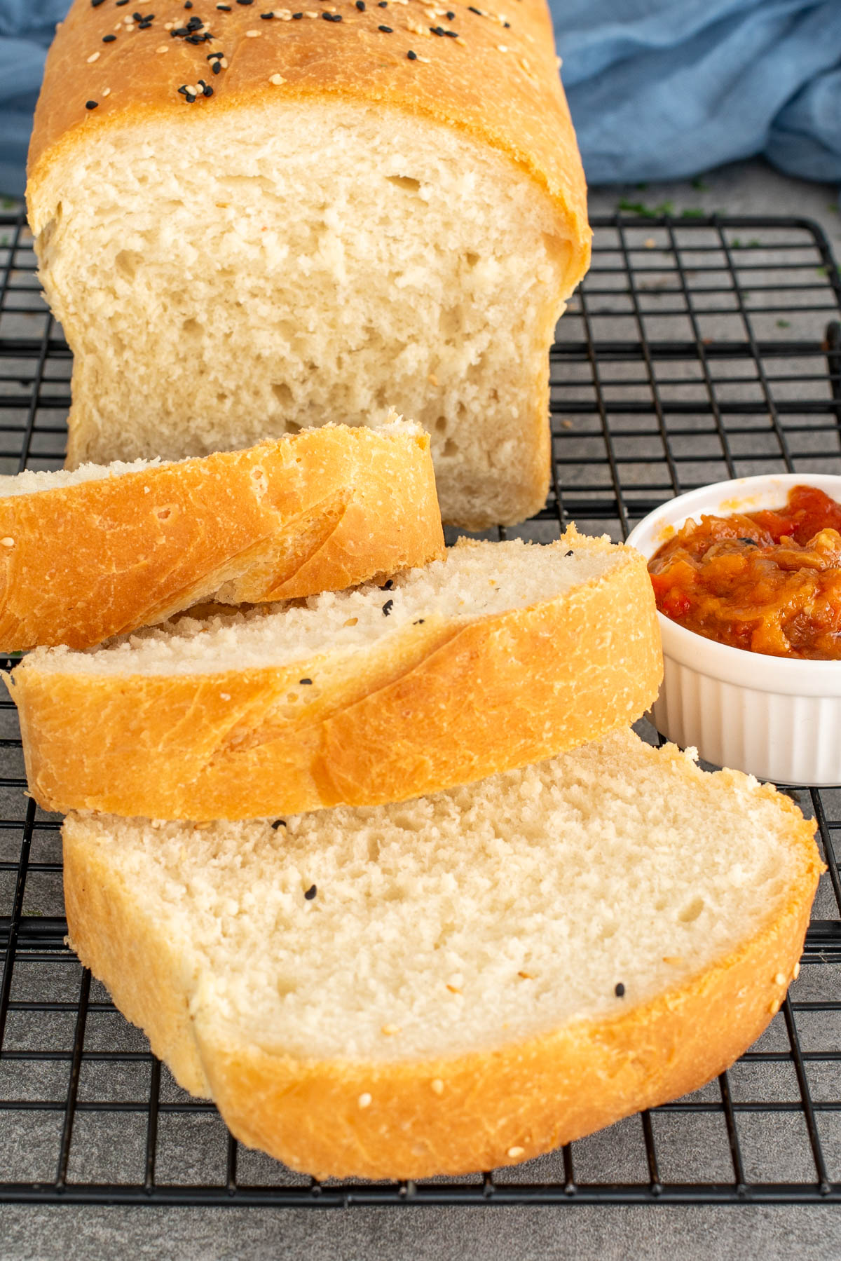 Pâine la tavă moale și pufoasă, cu crustă aurie și miez aerat, feliata.