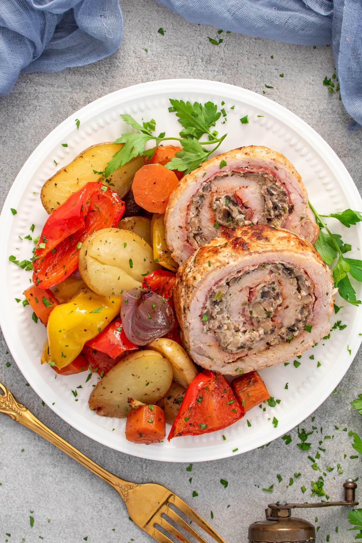 Felii de rulada de porc servite cu legume coapte.