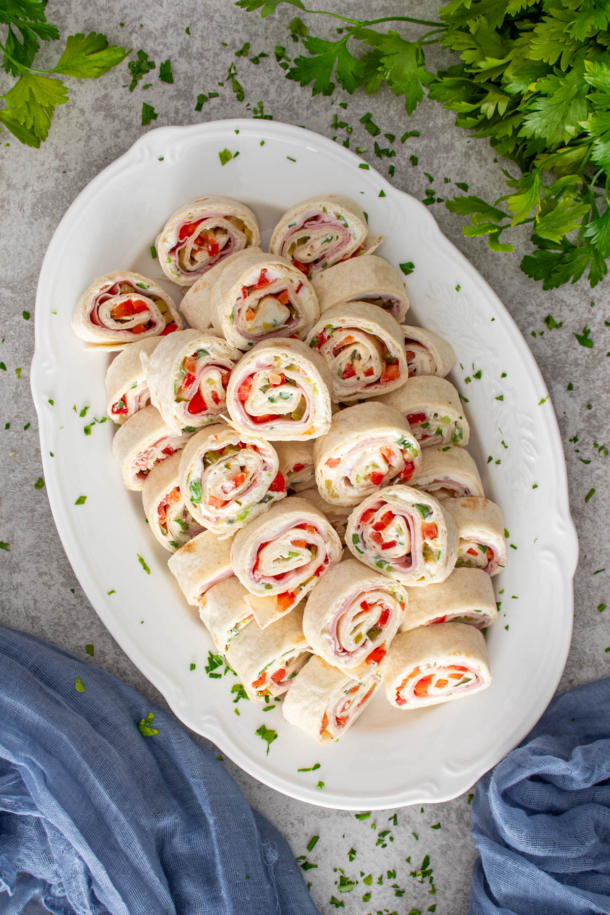 Rondele de rulata din tortilla cu crema de branza si sunca, servite pe platou alb.