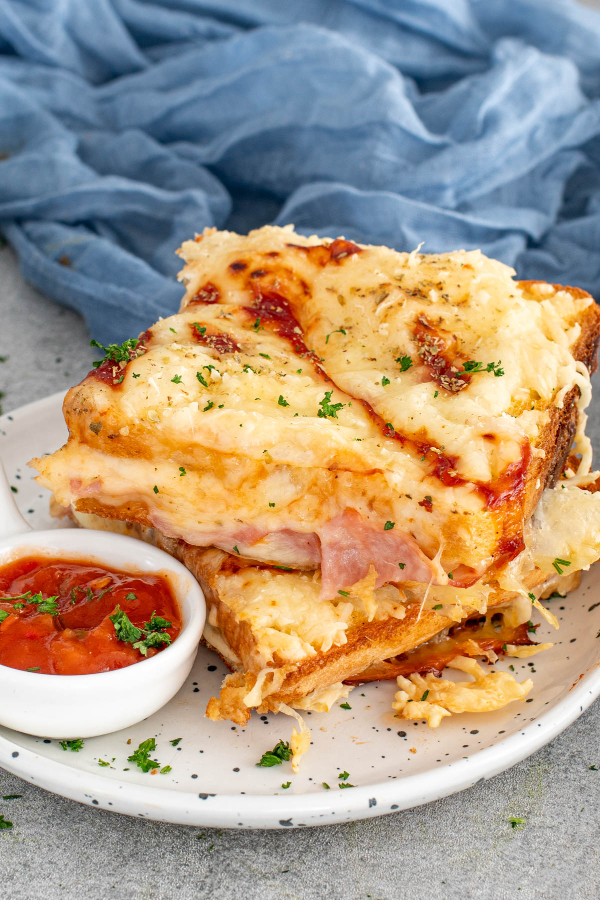 Sendvișuri gratinate cu p&acirc;ine &icirc;nmuiată &icirc;n ou, șuncă și mozzarella topita, rumenite perfect la cuptor.