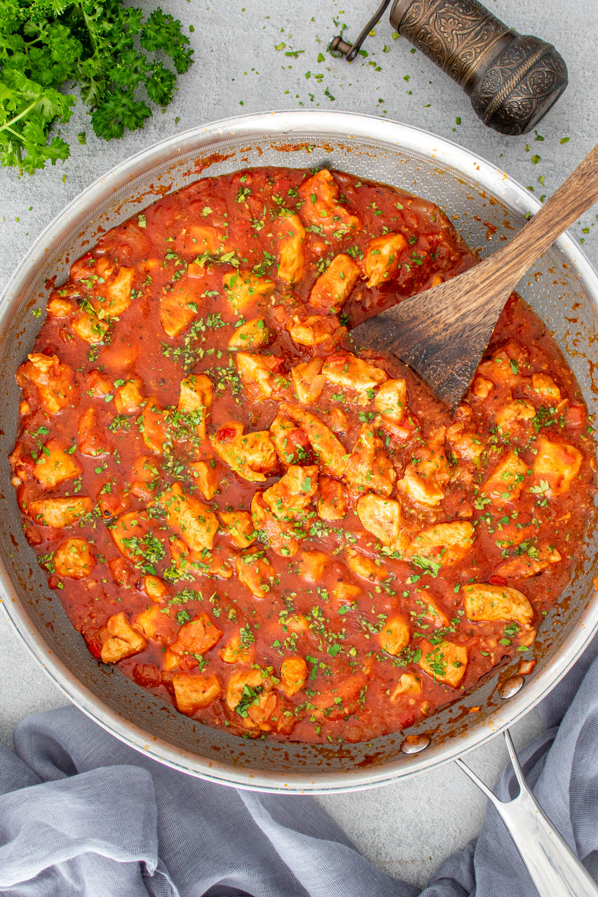 Tocăniță de pui &icirc;n sos de roșii, gătită &icirc;n tigaie si asezonata cu patrunjel proaspat tocat.