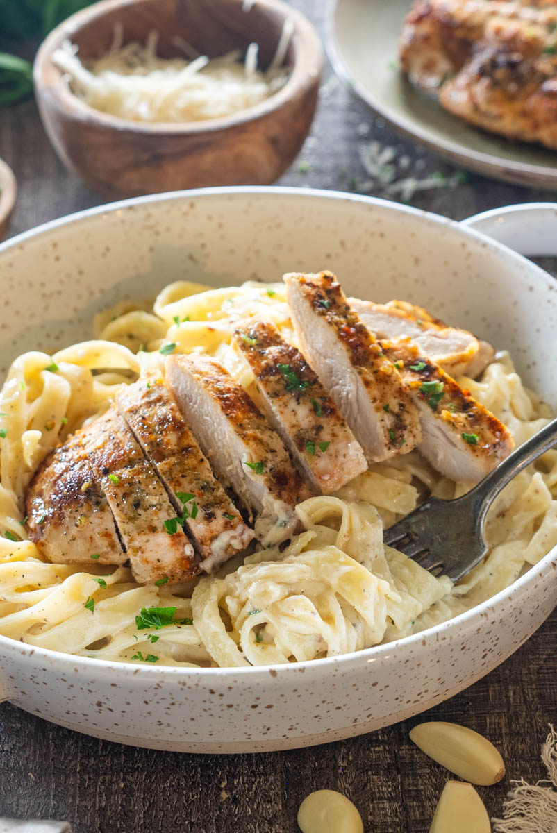 Tagliatelle Alfredo cu piept de pui rumenit și sos cremos de parmezan.