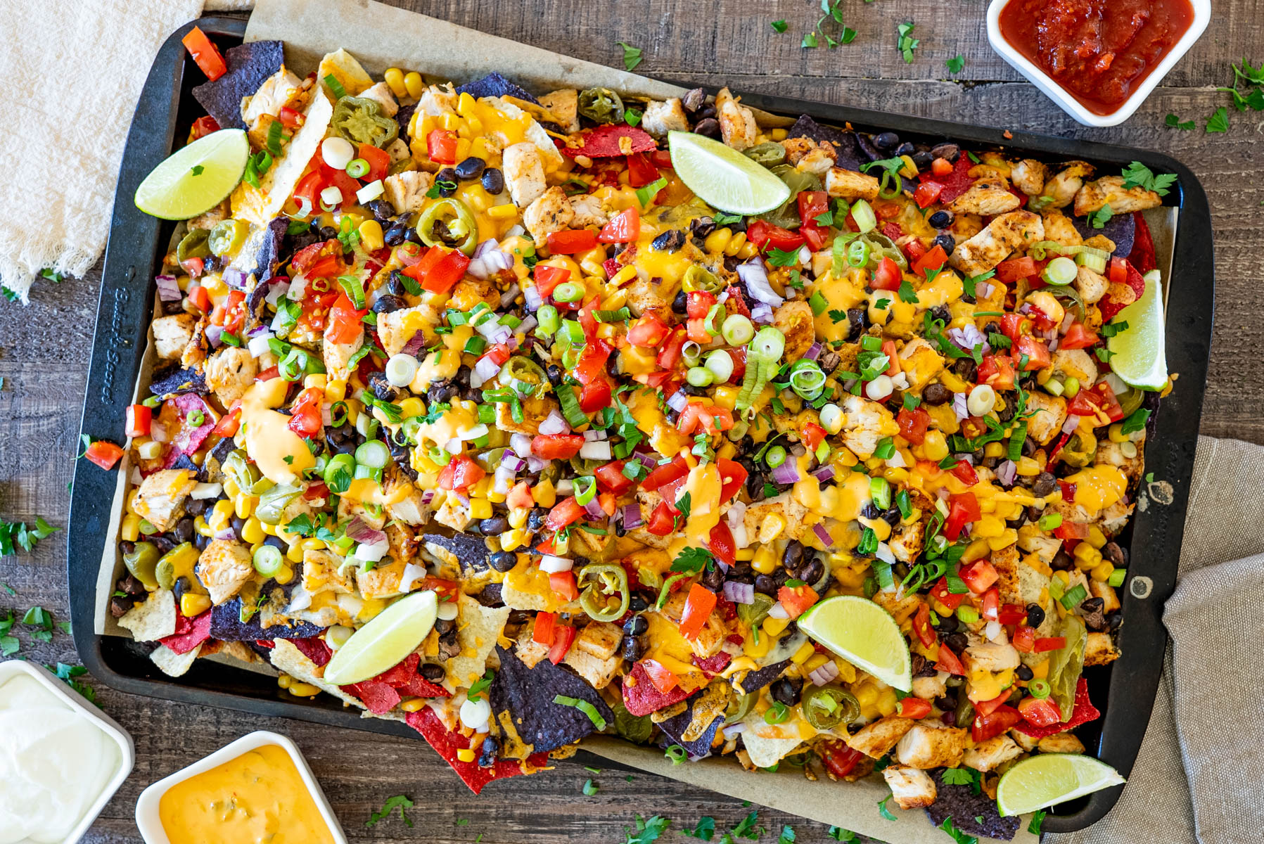 Tavă de nachos cu pui suculent, cheddar topit și toppinguri proaspete, perfectă pentru petreceri sau seri de film.