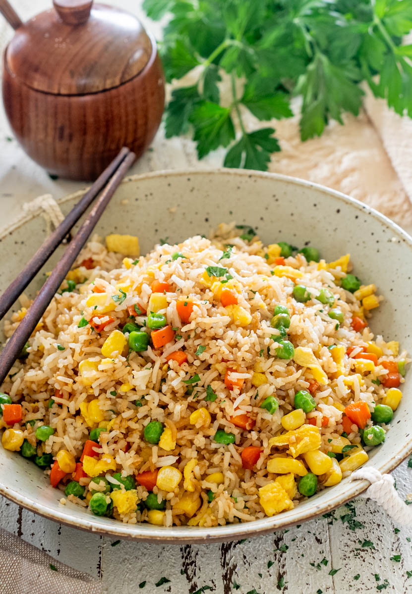 Orez chinezesc cu ou și legume, preparat cu mazăre, porumb, morcovi și sos de soia.