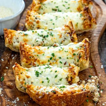 P&acirc;ine cu usturoi și mozzarella topită, presărată cu pătrunjel și parmezan.