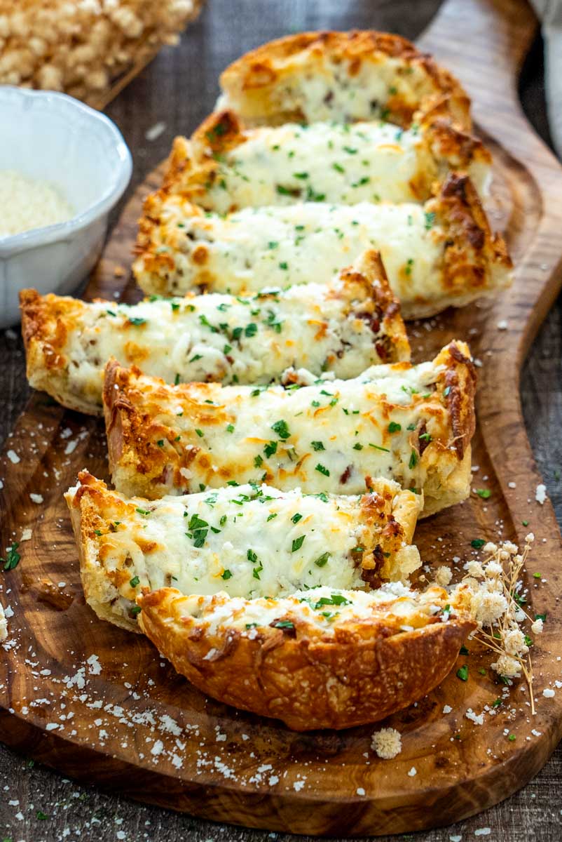 P&acirc;ine cu usturoi și mozzarella topită, presărată cu pătrunjel și parmezan.