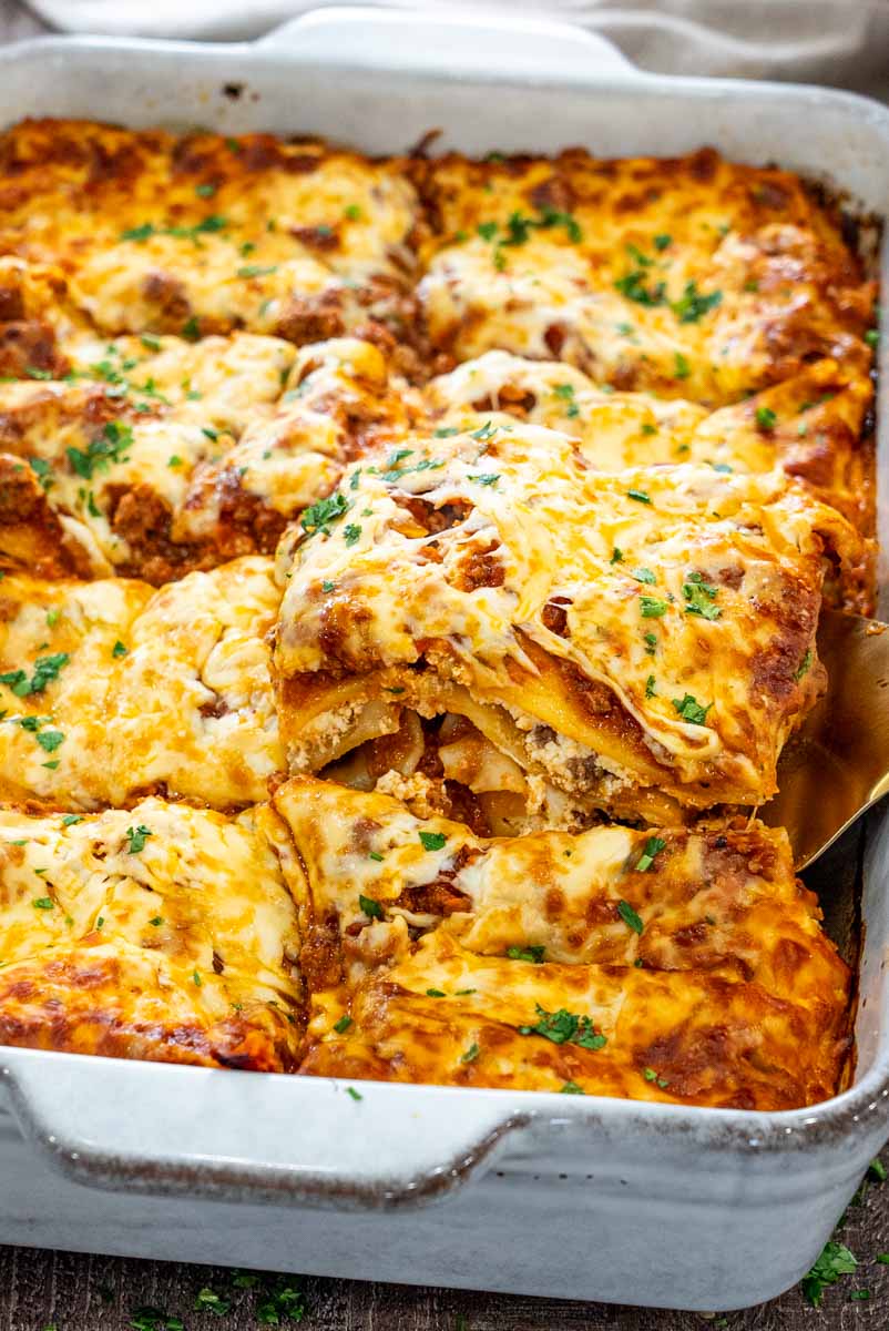 Lasagna cu carne și ricotta, cu straturi de paste, sos de carne și mozzarella rumenită, proaspăt scoasă din cuptor.
