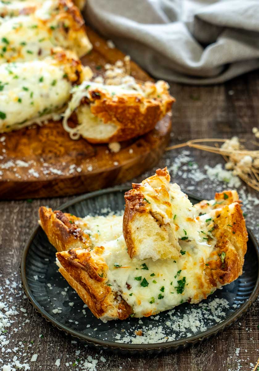 P&acirc;ine cu usturoi crocantă, acoperită cu mozzarella topită, parmezan și pătrunjel.