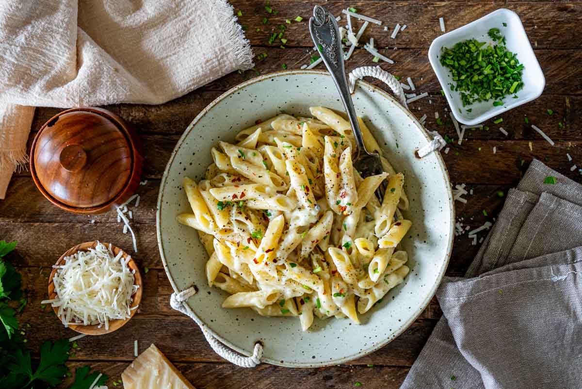 Paste penne Quattro Formaggi, fotografiate de sus și servite cu sos cremos de brânzeturi.