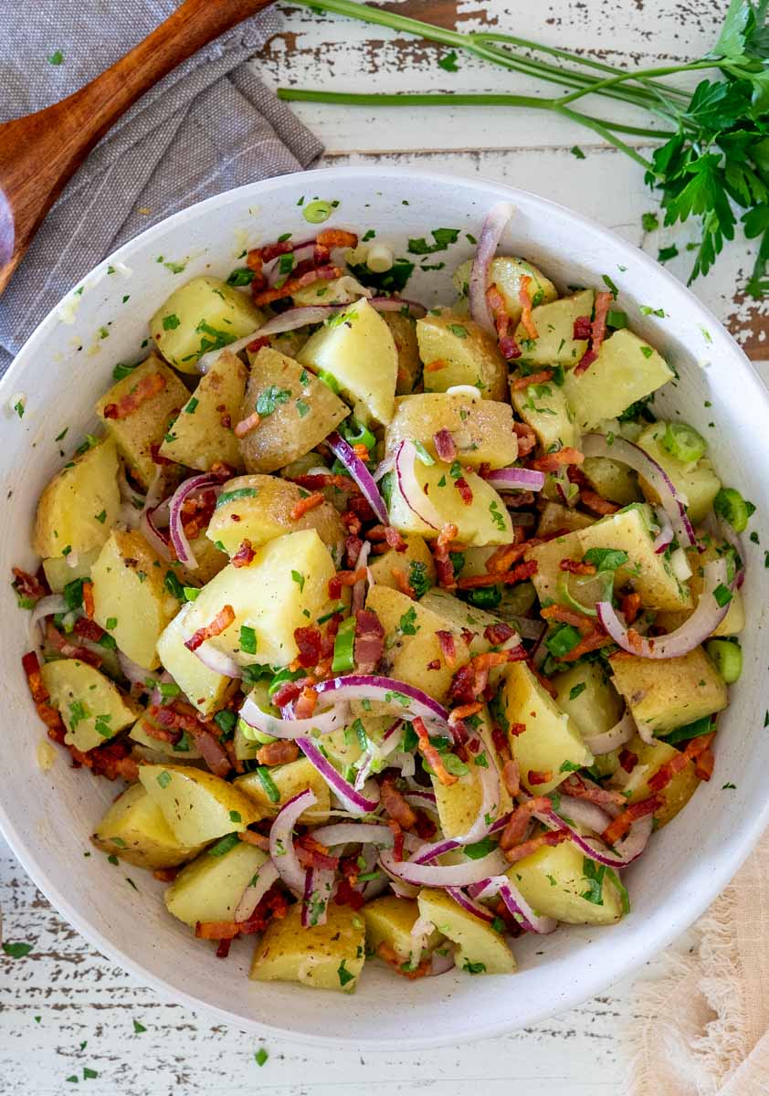 Salată germană de cartofi cu bacon și ceapă roșie, văzută de sus.